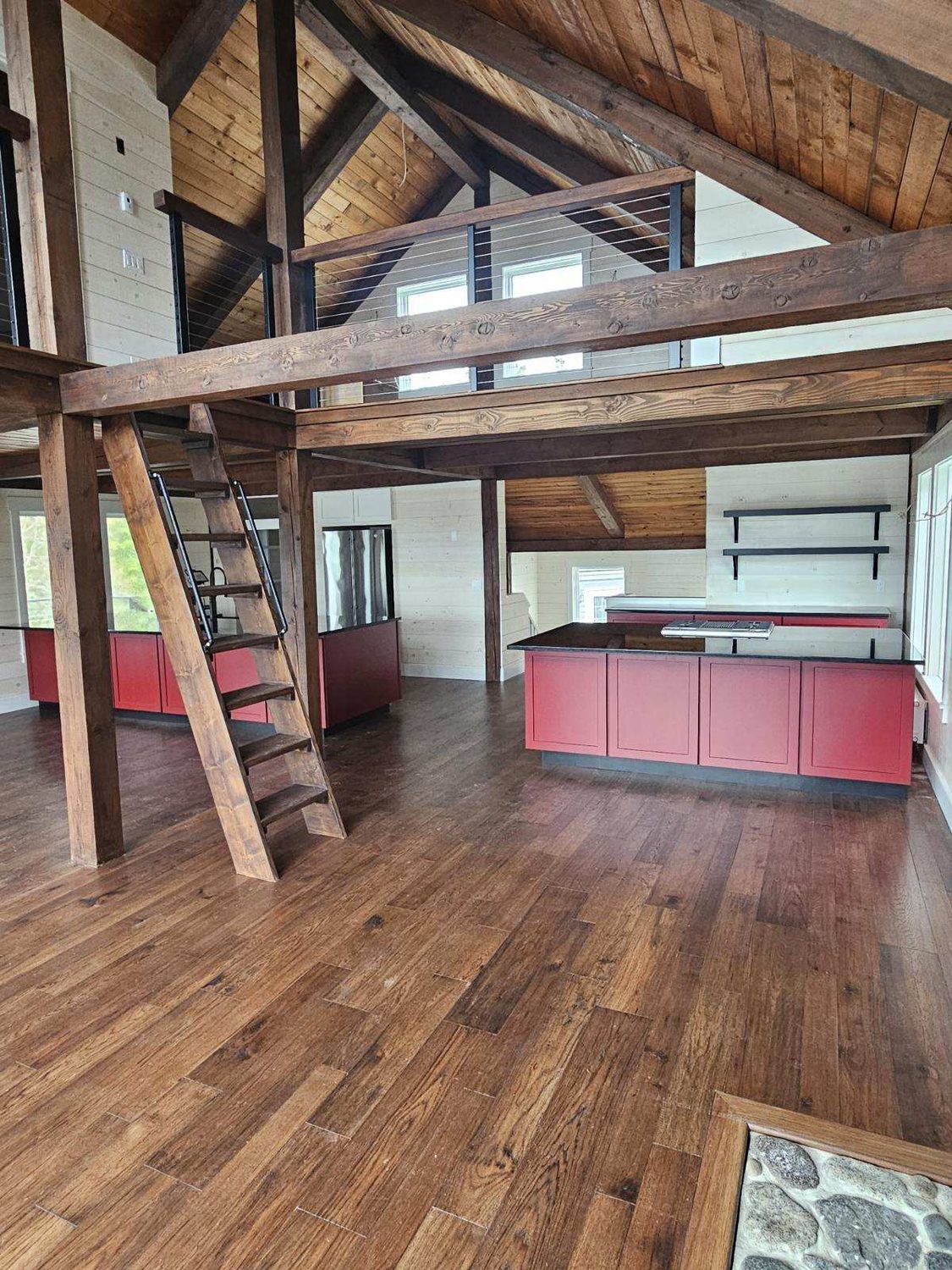 Post-and-beam loft overlooking the kitchen in a home built by L.E. Nichols & Son LLC — Harrington, ME